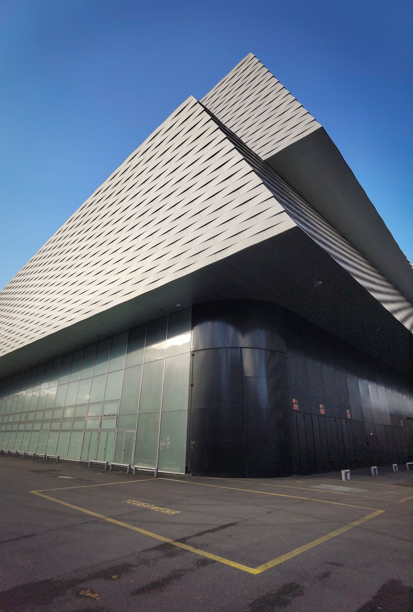 An angular building with a sharply cantilevered upper storey against a clear sky.