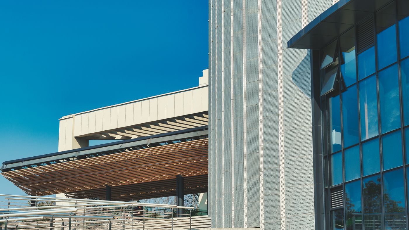A contemporary glazed building front seen from street level.