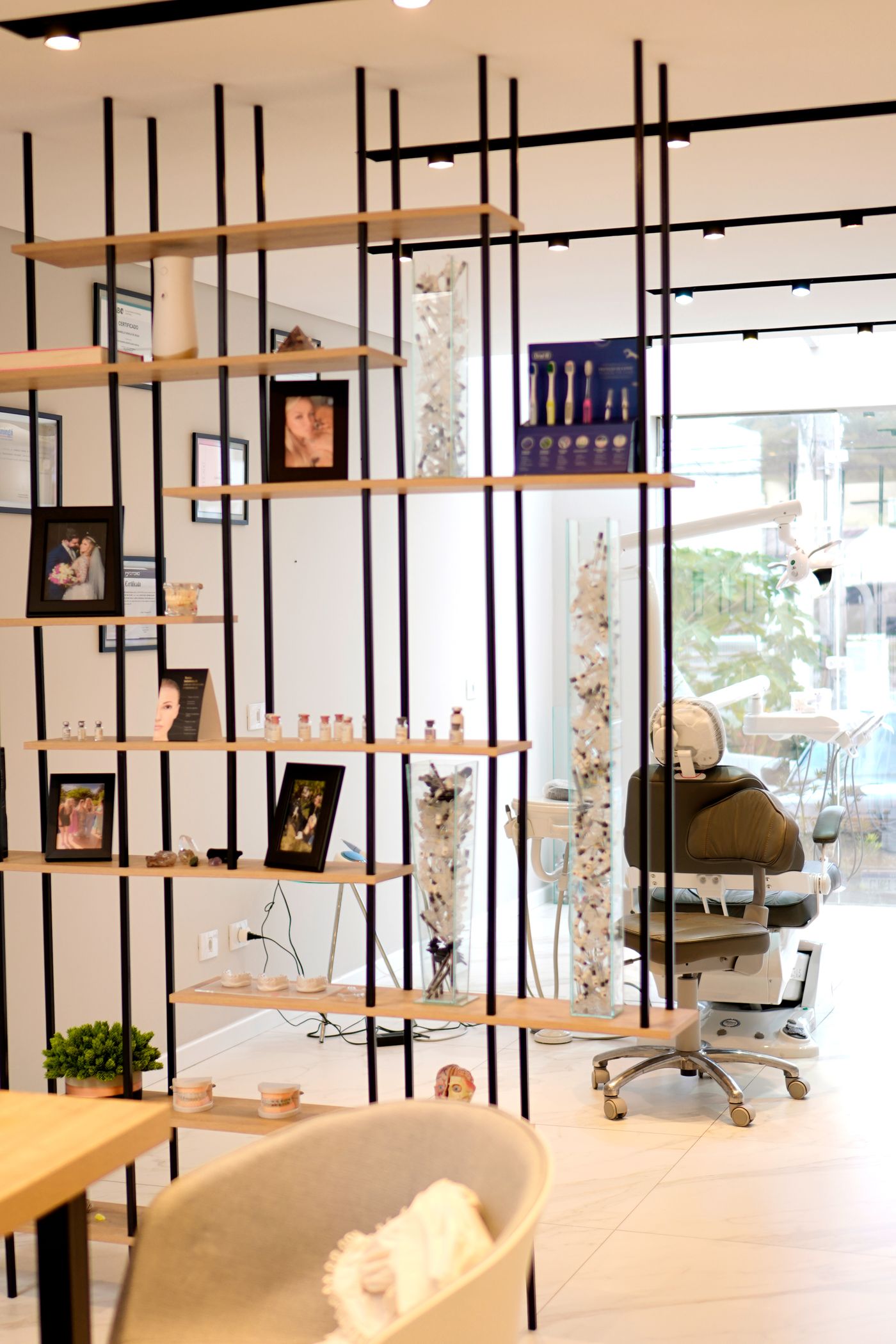 The practice interior, with an open shelf of framed photographs beside the treatment chair.