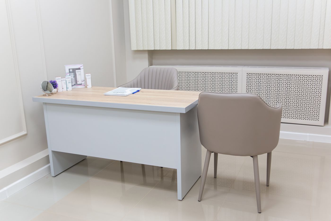 A consulting room at Marlow with a desk and two chairs.