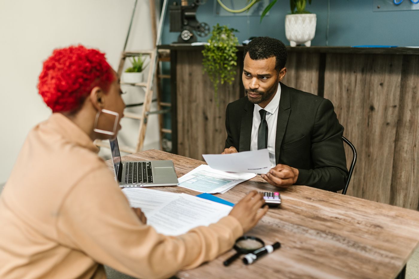 An adviser and a client reviewing documents across a desk.