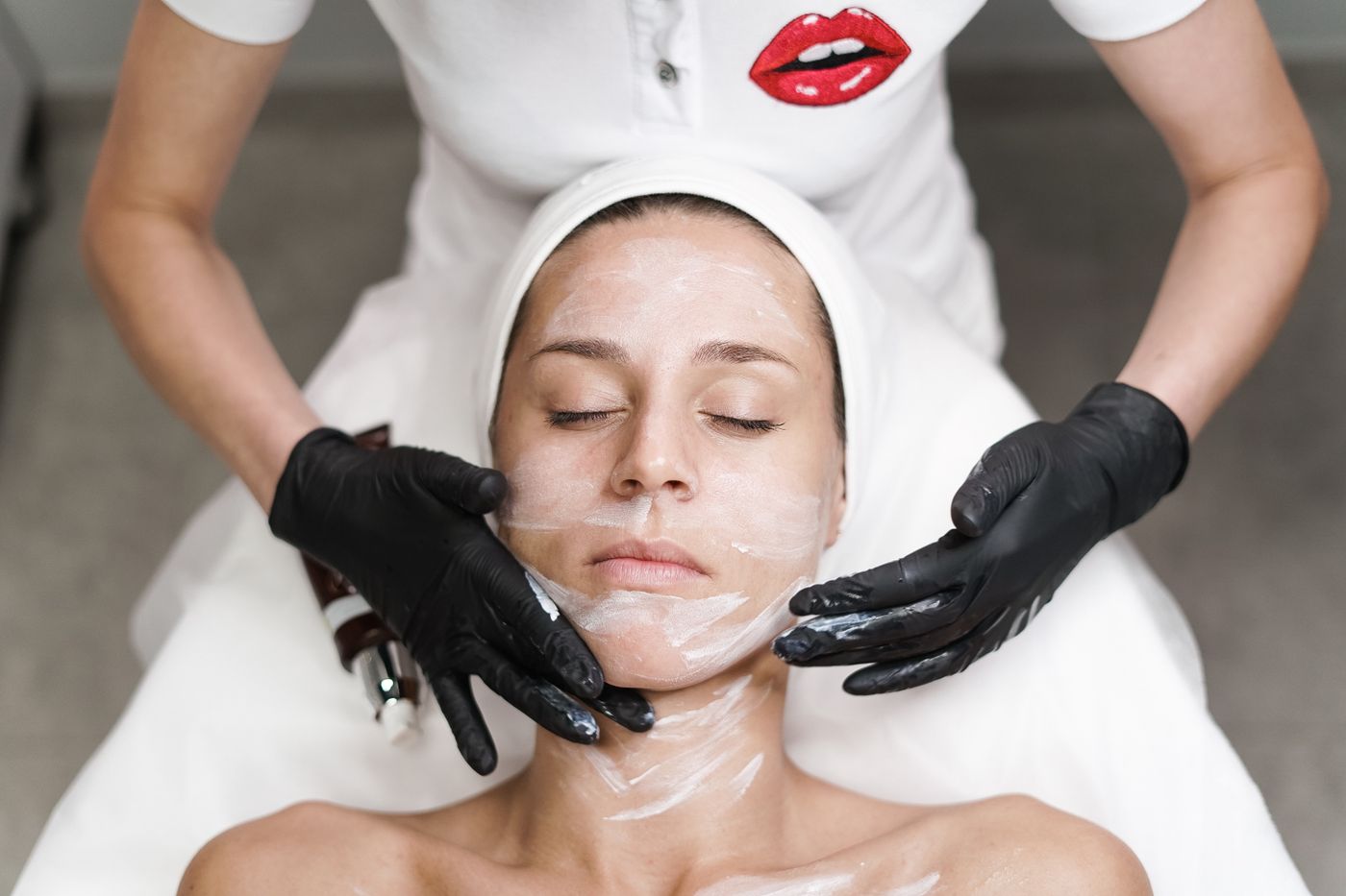 A practitioner applying product during a facial treatment.