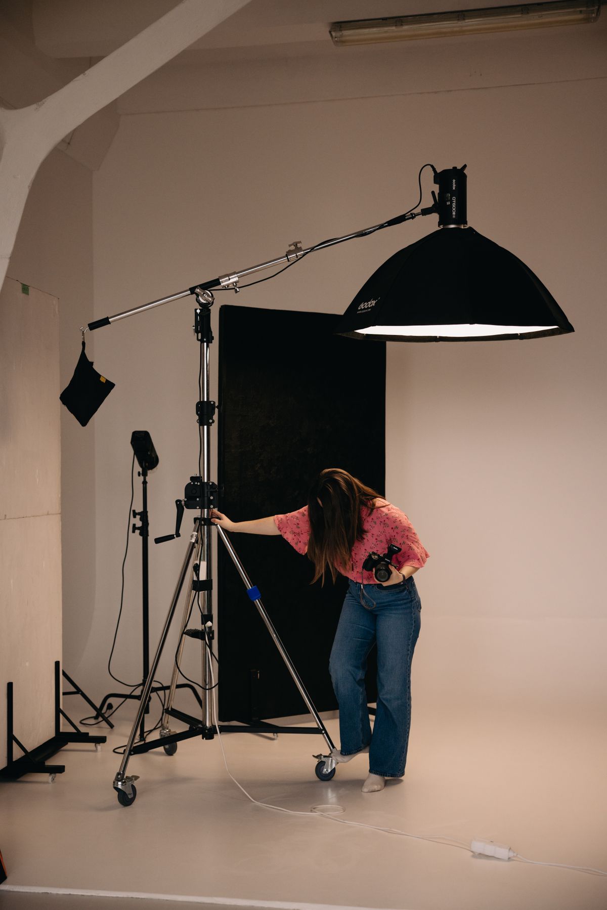 The main studio room with a boom-mounted light and a black backdrop.