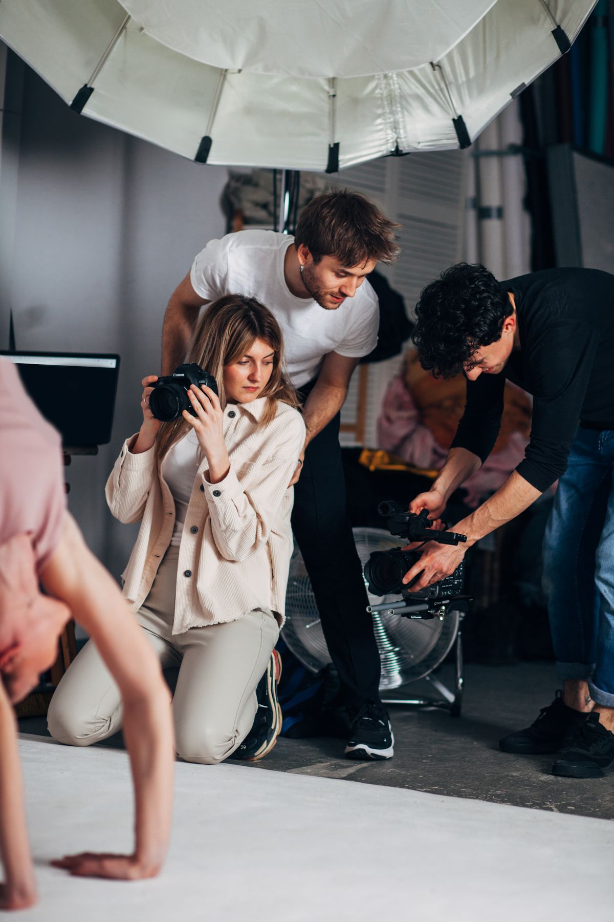 A crew of three working a shoot with a camera and a video rig.